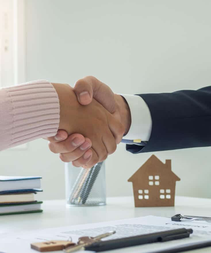 149249213-sales-agents-and-customers-shaking-hands-after-signing-a-contract-to-buy-a-new-house-or-apartment-mo